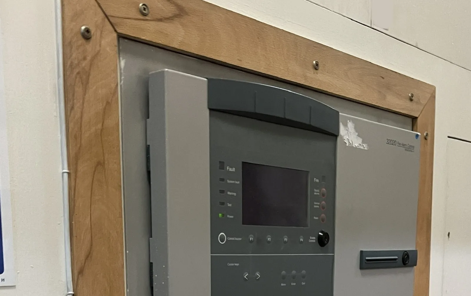 Flush-mounted addressable fire alarm control panel with a small display, keypad and status lights